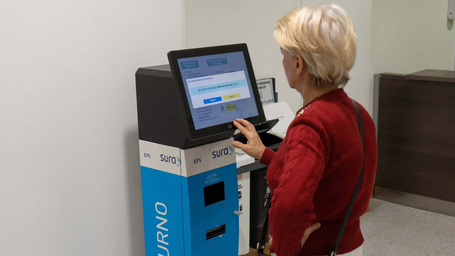 Older woman requesting her ticket at a touch-screen self-service kiosk with integrated document reader